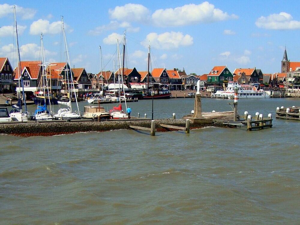 De jachthaven van Volendam met zeilboten en de huizen aan de dijk